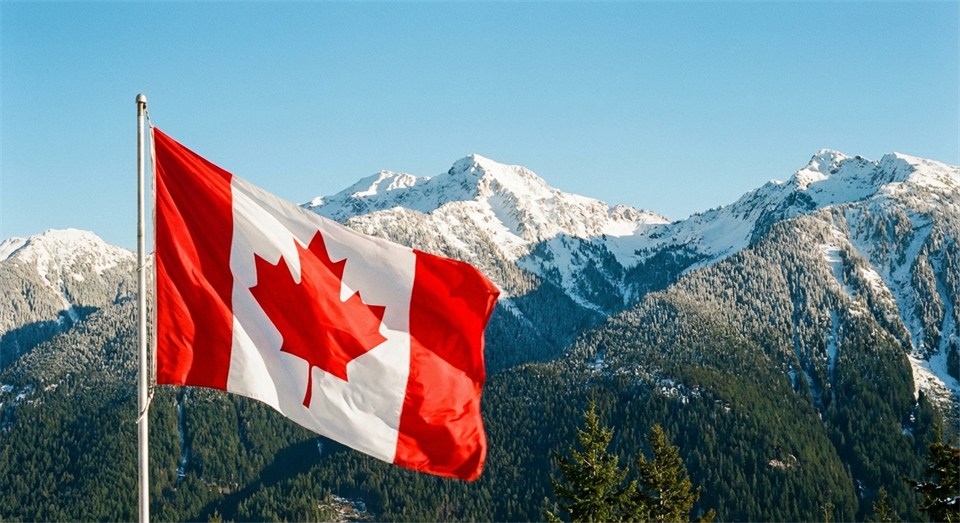 Die kanadische Flagge vor großartiger Natur mit Bergen