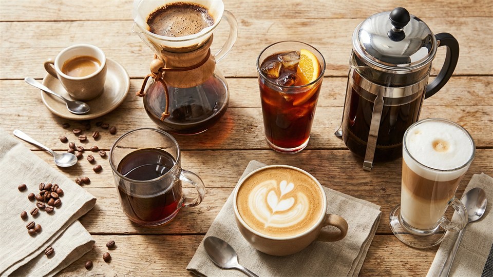 Forskellige kaffetyper i glas og kopper på et bord